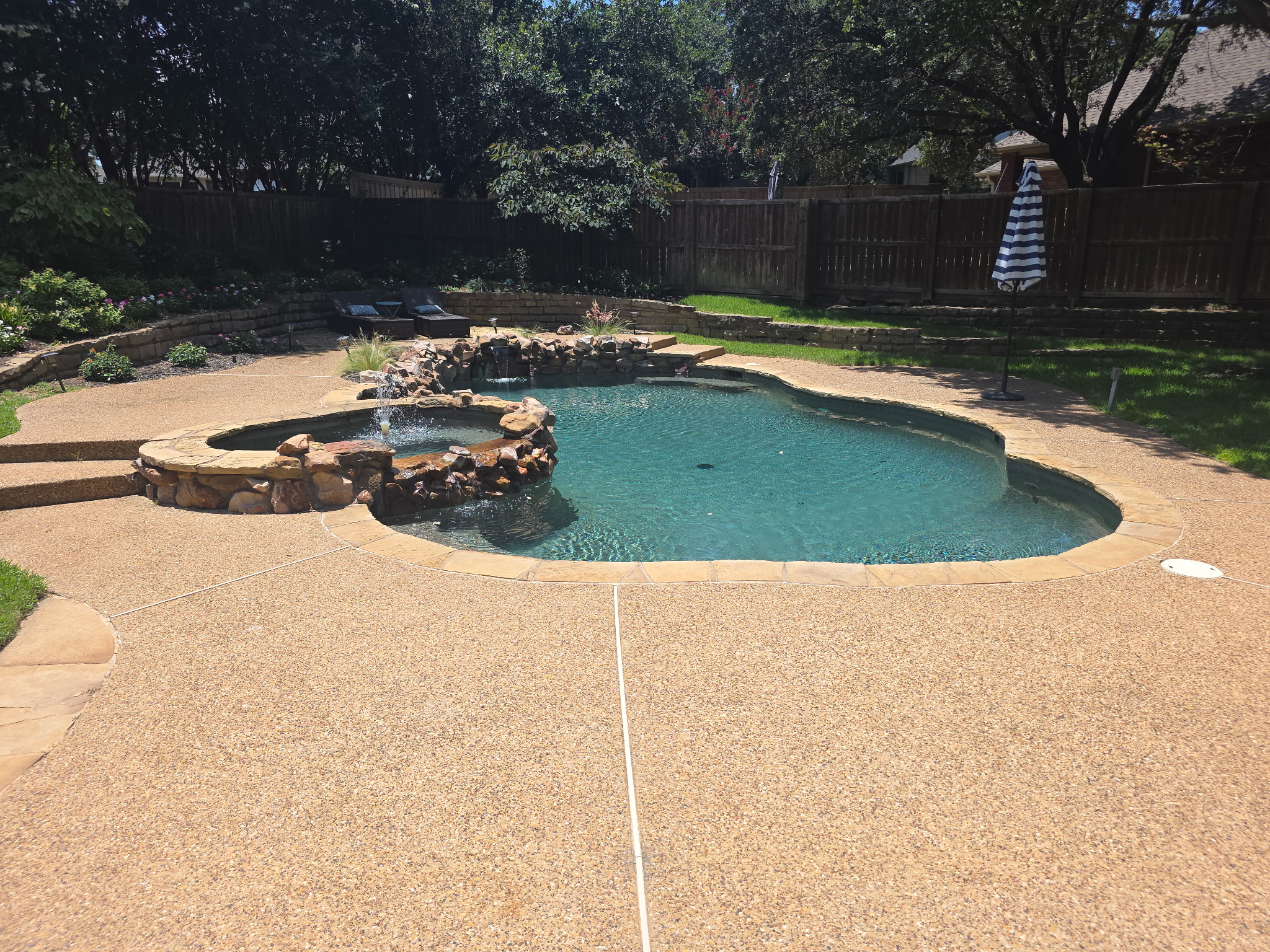 Modern infinity-edge pool with tanning ledge maintained by Crimson Pool Service